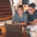 Couple looking at computer with notes open